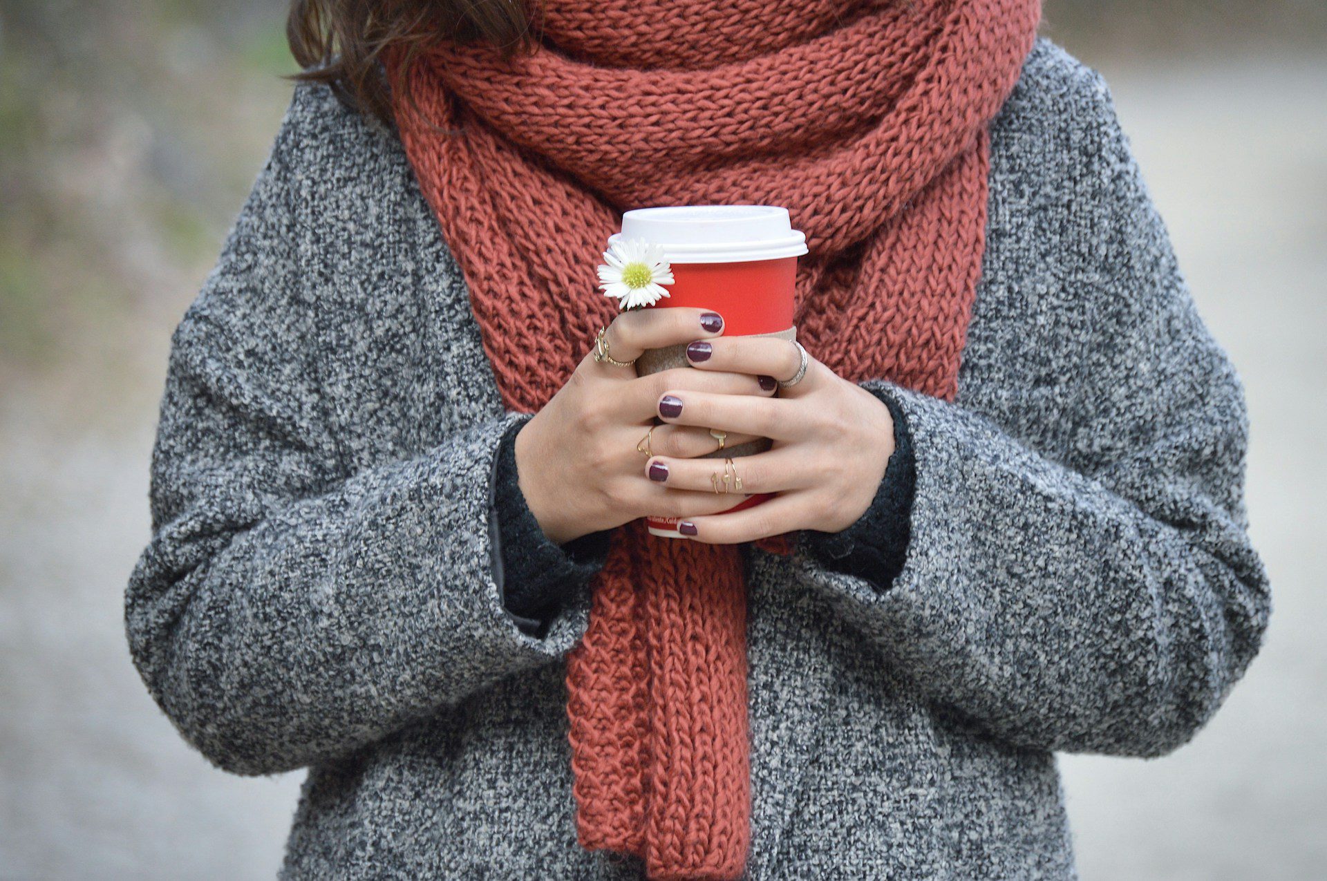 Person holding red and white disposable cup.
